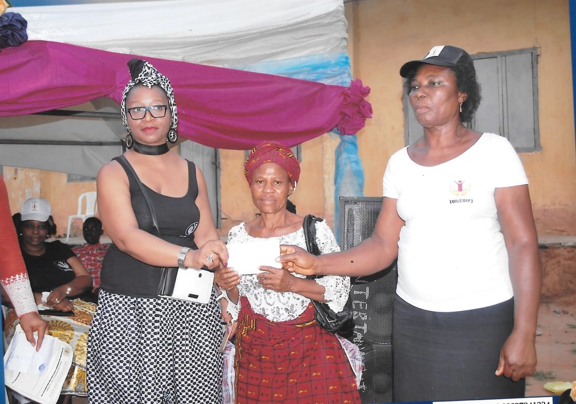 Beneficiary receiving her cheque from UNEOIF founder and her Vice